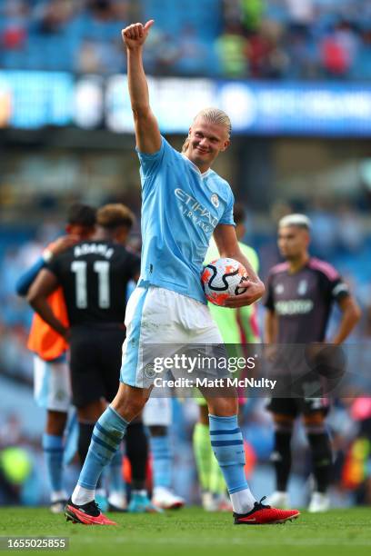 Erling Haaland of Manchester City acknowledges the fans as he carries the matchball after scoring a hat-trick during the Premier League match between...