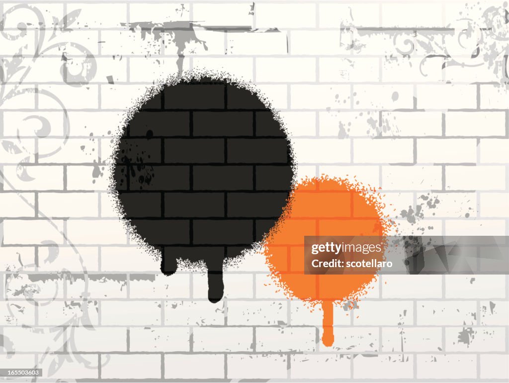 A black and an orange circle painted onto white brick