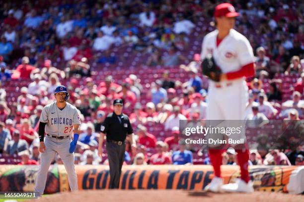 Seiya Suzuki of the Chicago Cubs leads off first base as Lucas Sims of the Cincinnati Reds pitches in the sixth inning during game one of a...