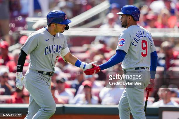 Seiya Suzuki and Jeimer Candelario of the Chicago Cubs celebrate after Suzuki hit a home run in the eighth inning against the Cincinnati Reds during...
