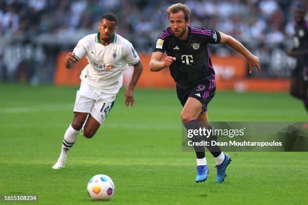 Harry Kane of Bayern Munich battles for possession with Niclas Fuellkrug of Borussia Mönchengladbach during the Bundesliga match between Borussia...