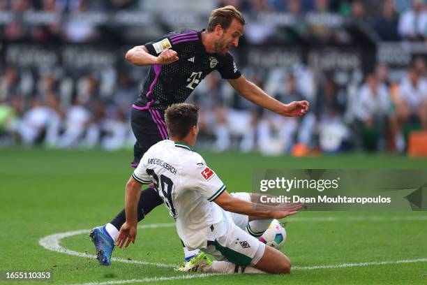 Harry Kane of Bayern Munich is tackled by Maximilian Wöber of Borussia Mönchengladbach during the Bundesliga match between Borussia Mönchengladbach...
