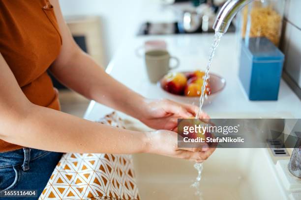 woman washing seasonal fresh apples - apple water splashing stock pictures, royalty-free photos & images