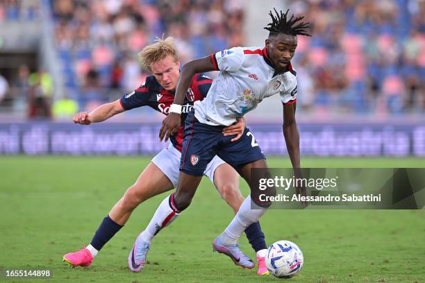 Antoine Makoumbou of Cagliari holds off Victor Kristiansen of Bologna during the Serie A TIM match between Bologna FC and Cagliari Calcio at Stadio...