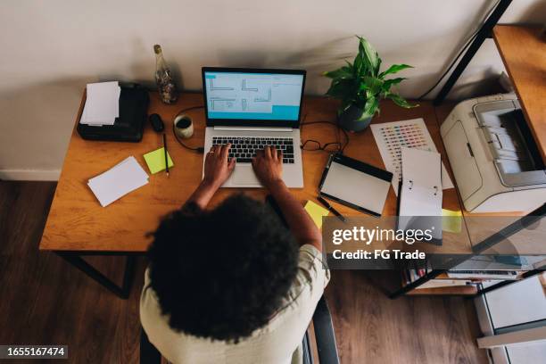 high angle view of a mature woman working with laptop at home - sticky-notes-covering-computer-monitor stock pictures, royalty-free photos & images