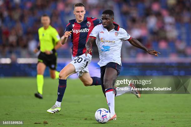 Zito Luvumbo of Cagliari is put under pressure by Michel Aebischer of Bologna during the Serie A TIM match between Bologna FC and Cagliari Calcio at...