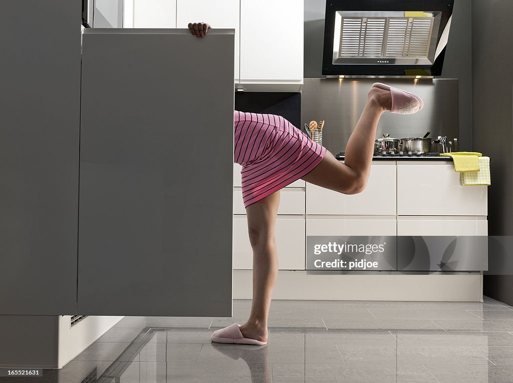 Teenager Mädchen schaut in den Kühlschrank zu einem kleinen snack um Mitternacht