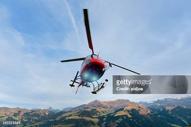 red rescue helicopter landing on mountain - air ambulance stock pictures, royalty-free photos & images