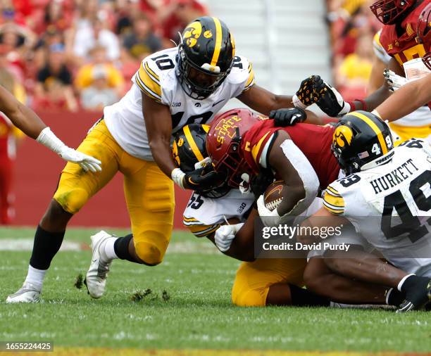 Running back Cartevious Norton of the Iowa State Cyclones is tackled by linebacker Nick Jackson, defensive lineman Jeremiah Pittman, and defensive...