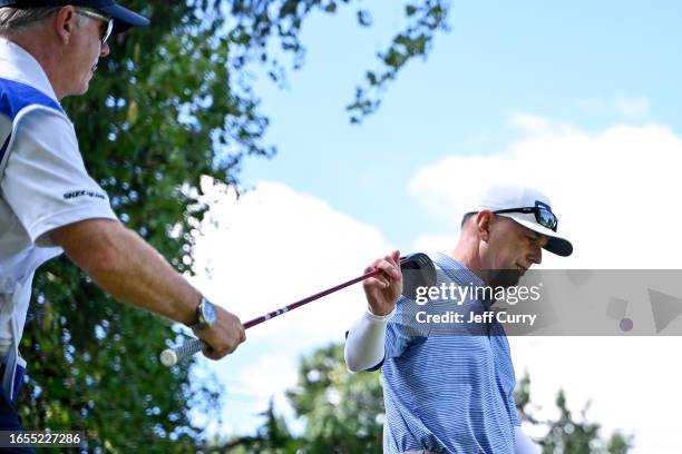 Kevin Sutherland hands his driver to his caddie after hitting his first shot on the ninth hole during the second round of the Ascension Charity...