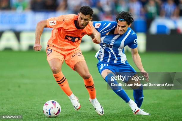 Selim Amallah of Valencia CF duels for the ball with Ianis Hagi of Deportivo Alaves during the LaLiga EA Sports match between Deportivo Alaves and...