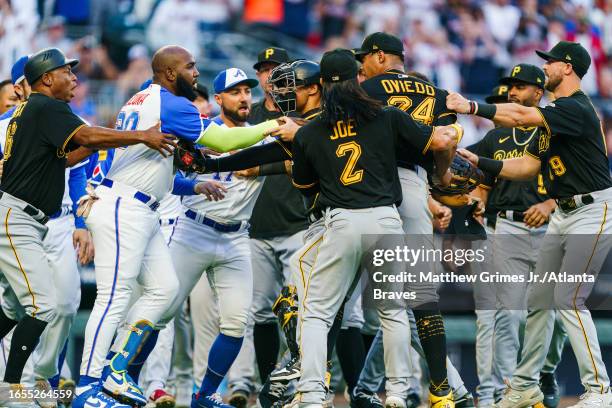 Marcell Ozuna and Kevin Pillar of the Atlanta Braves, and Endy Rodriguez, Tarrik Brock, and Johan Oviedo of the Pittsburgh Pirates during a...