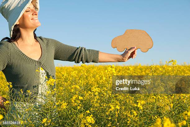 woman holding car shape outdoors - person holding flowers with high energy stock-fotos und bilder