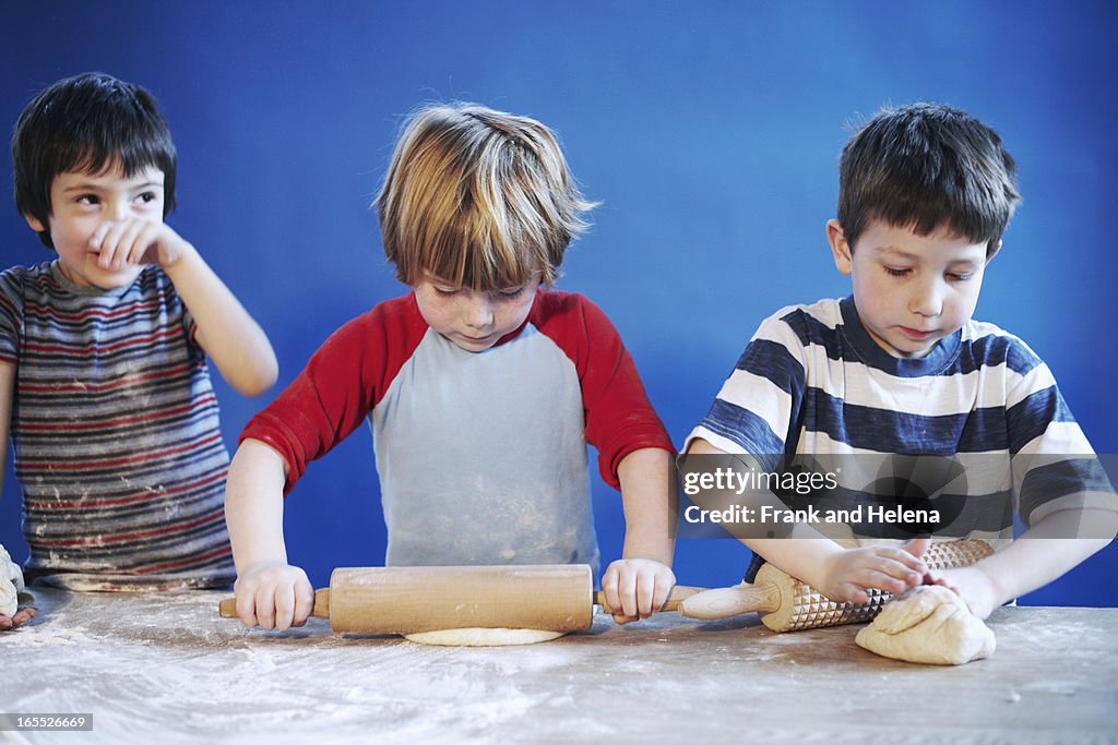 Boys rolling out dough with pins