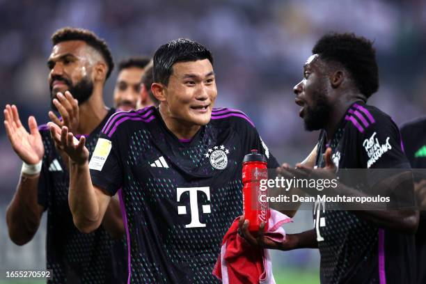 Kim Min-Jae of Bayern Munich interacts with Alphonso Davies of Bayern Munich following the team's victory during the Bundesliga match between...