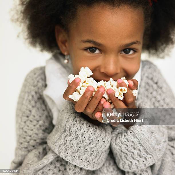 girl eating handful of popcorn - handful stock pictures, royalty-free photos & images