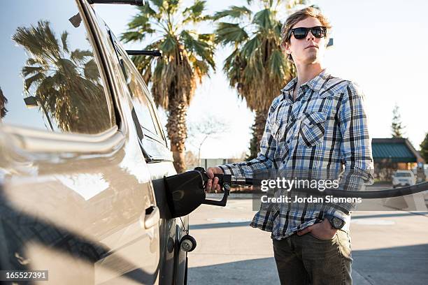 a man pumping gas. - filling petrol stock pictures, royalty-free photos & images