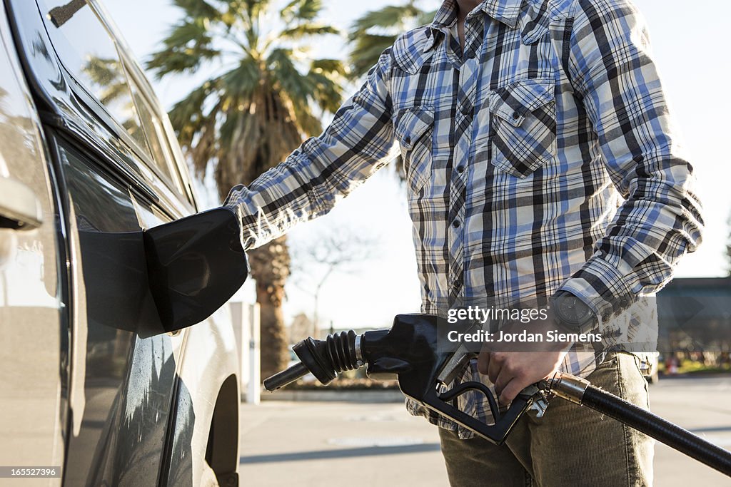 A man pumping gas.