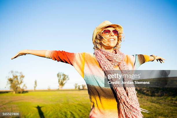 a woman holding out her arms in a field. - redding california stockfoto's en -beelden