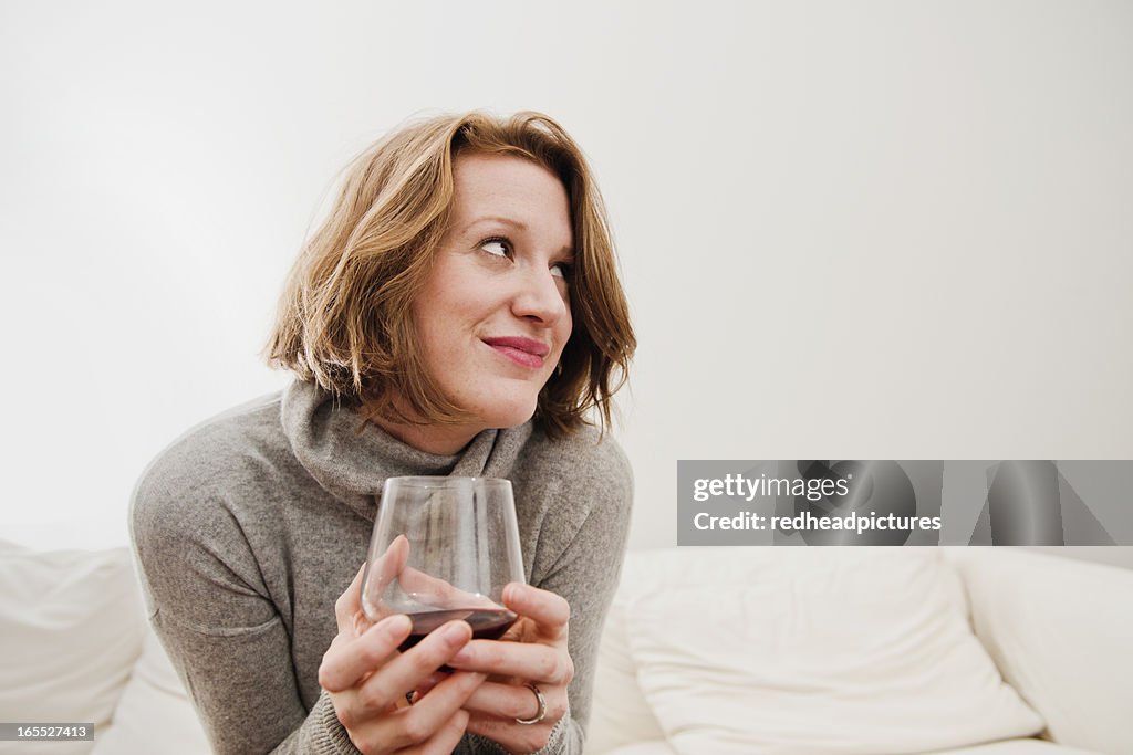 Woman drinking wine on sofa