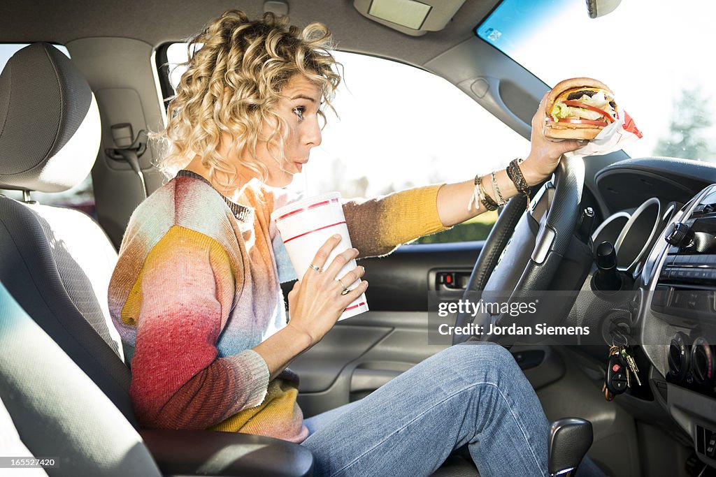 Eating fast food hamburgers and driving.