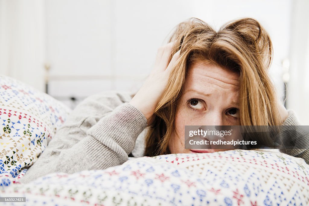 Woman ruffling her hair on bed