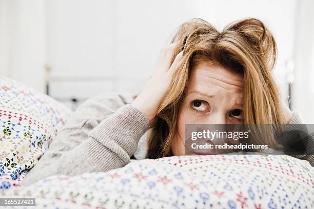woman ruffling her hair on bed - ruffling stock pictures, royalty-free photos & images