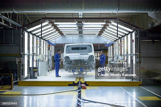 workers and vehicle in inspection station in car factory - automobile assembly stock pictures, royalty-free photos & images