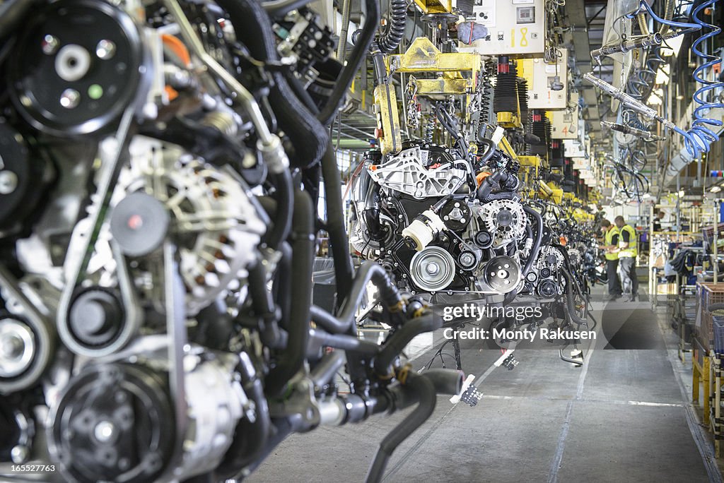 Workers on engine production line in car factory