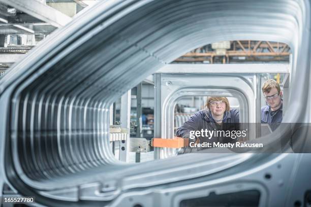 apprentices inspecting section of car body in car plant - human body part foto e immagini stock