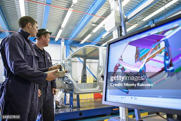 apprentices wearing boiler suits measuring car body in car plant, computer image on monitor in foreground - automotive design stock pictures, royalty-free photos & images