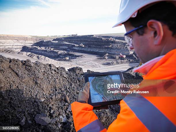 ecologist using digital tablet surveying surface coal mine site, elevated view - mijnindustrie stockfoto's en -beelden