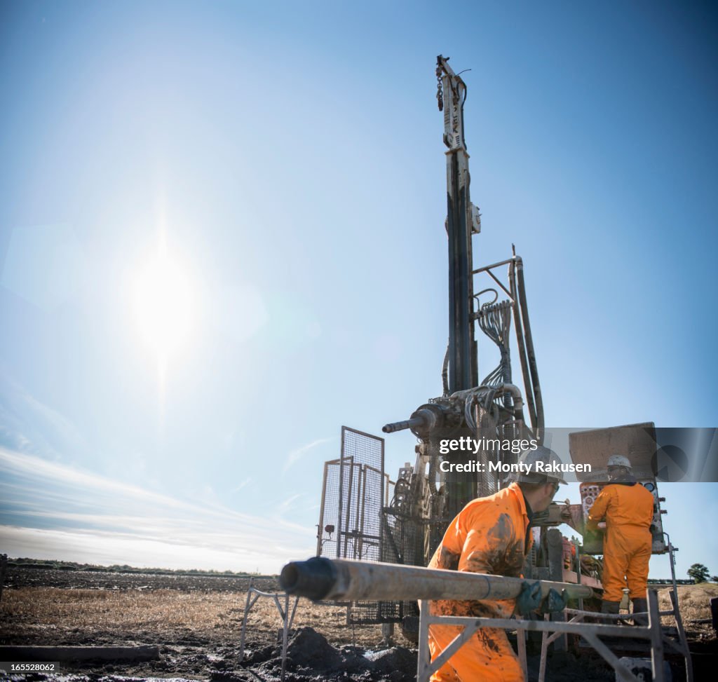 Workers looking for coal seams with drilling rig at surface coal mine