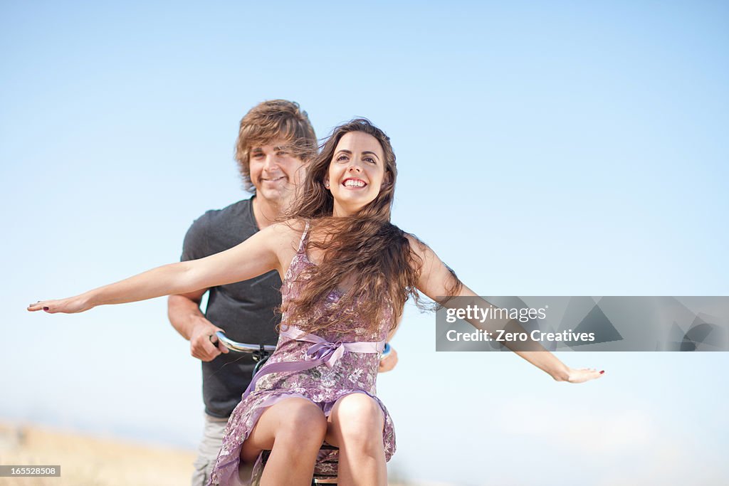 Couple riding bicycle outdoors