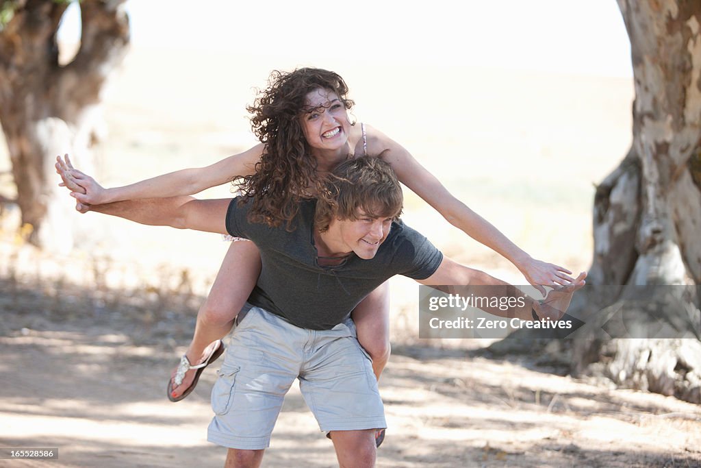 Man carrying girlfriend outdoors