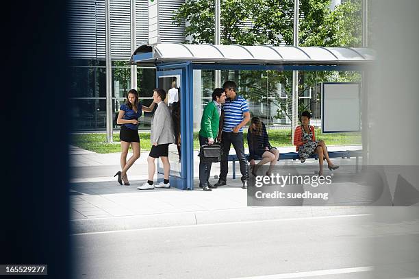 people waiting at bus stop - bus shelter ストックフォトと画像