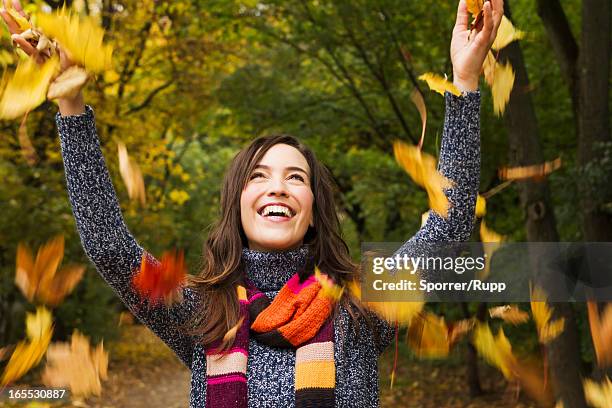 woman playing in autumn leaves - throwing leaves stock pictures, royalty-free photos & images