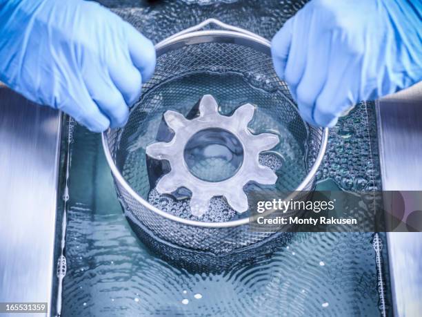 worker cleaning engineering products using ultrasonics - worker cleaning engineering products using ultrasonics stock pictures, royalty-free photos & images