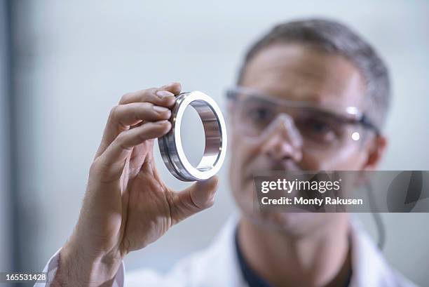 worker inspecting engineering parts that have been cleaned using ultrasonics - vestido metalizado imagens e fotografias de stock