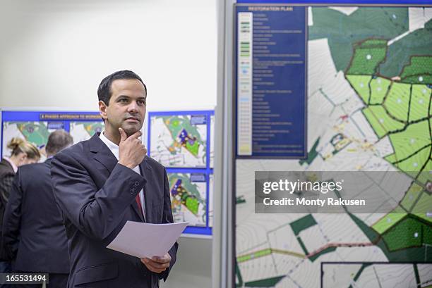 member of public inspecting proposed planning inquiry in town hall - businessman looking at map stock pictures, royalty-free photos & images