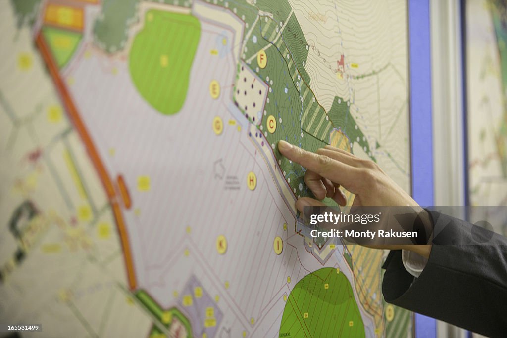 Member of public pointing at map of proposed planning inquiry in town hall