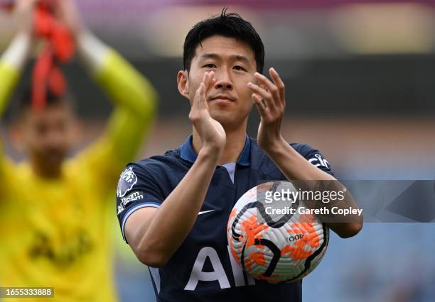 Heung-Min Son of Tottenham Hotspur applauds the fans as he carries the matchball after scoring a hat-trick after the Premier League match between...