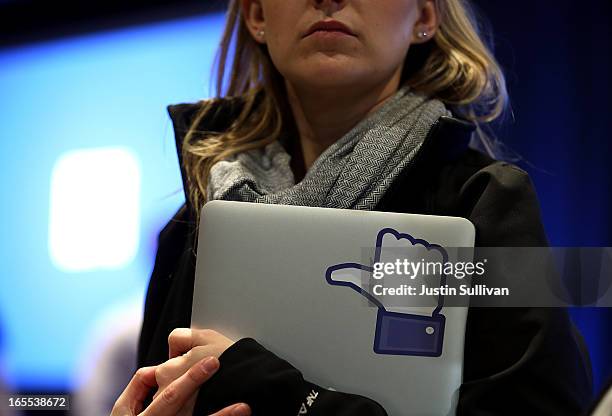 Facebook employee holds a laptop with a "like" sticker on it during an event at Facebook headquarters during an event at Facebook headquarters on...