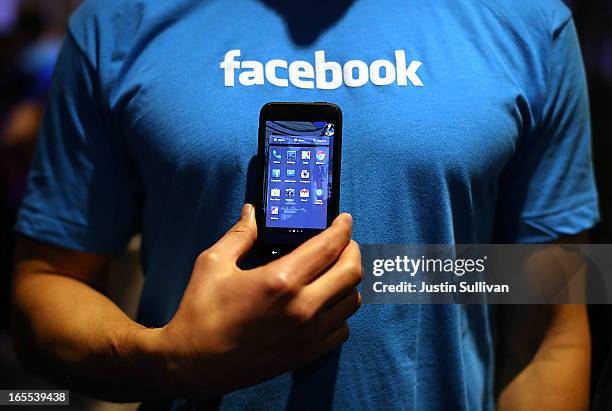 Facebook employee holds a phone that is running the new "Home" program during an event at Facebook headquarters during an event at Facebook...