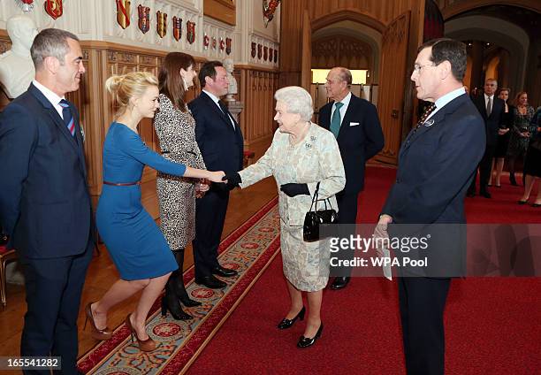 Queen Elizabeth II meets actress Carey Mulligan as actor James Nesbitt looks on at a reception for the British Film Industry at Windsor Castle on...