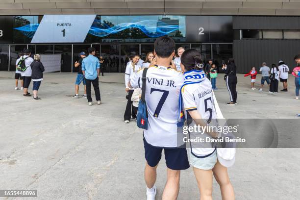 Fans with Vinicius JR shirt and Bellingham takes a photo of other fans in the exterior of the stadium during the La Liga match between Real Madrid...