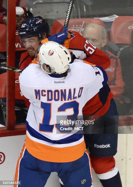 New York Islanders right wing Colin McDonald checks Washington Capitals defenseman Mike Green in the third period at the Verizon Center in...