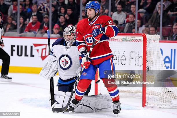 Brian Gionta of the Montreal Canadiens deflects the puck past Ondrej Pavelec of the Winnipeg Jets to score during the NHL game at the Bell Centre on...