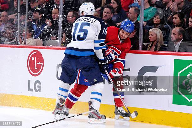 Mike Santorelli of the Winnipeg Jets body checks Davis Drewiske of the Montreal Canadiens during the NHL game at the Bell Centre on April 4, 2013 in...