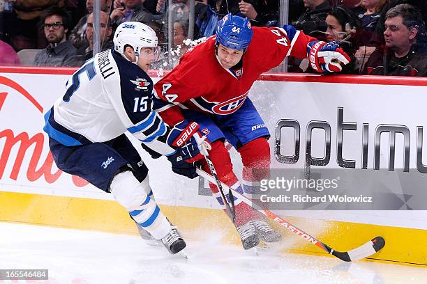 Mike Santorelli of the Winnipeg Jets and Davis Drewiske of the Montreal Canadiens battle for the puck during the NHL game at the Bell Centre on April...